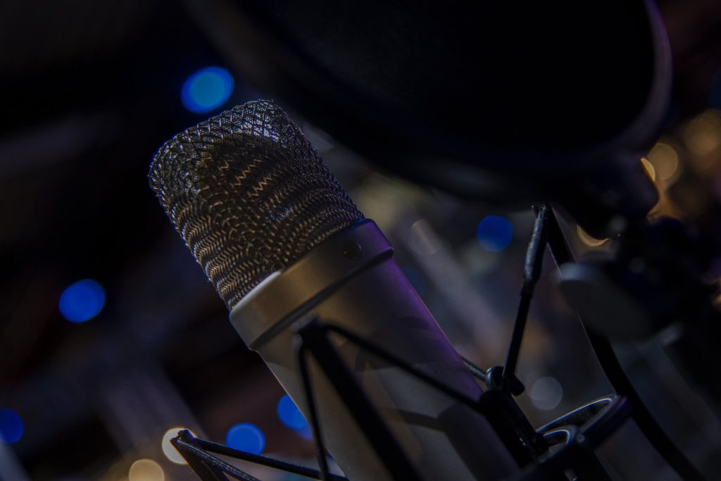 A condenser microphone in close detail against dark bokeh